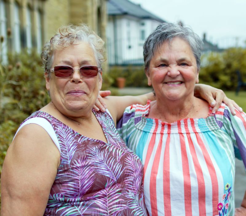 two adults embracing in a hug outdoors